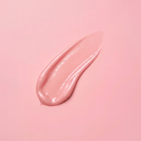 A swatch of frank body Firming Body Glaze showing the pearly pink gel texture on a pink background.