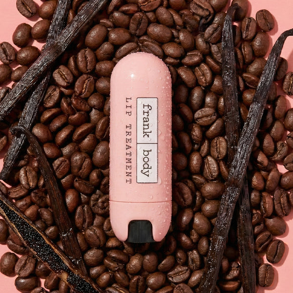 Pink lip balm with 'frank body' branding on coffee beans and vanilla beans.
