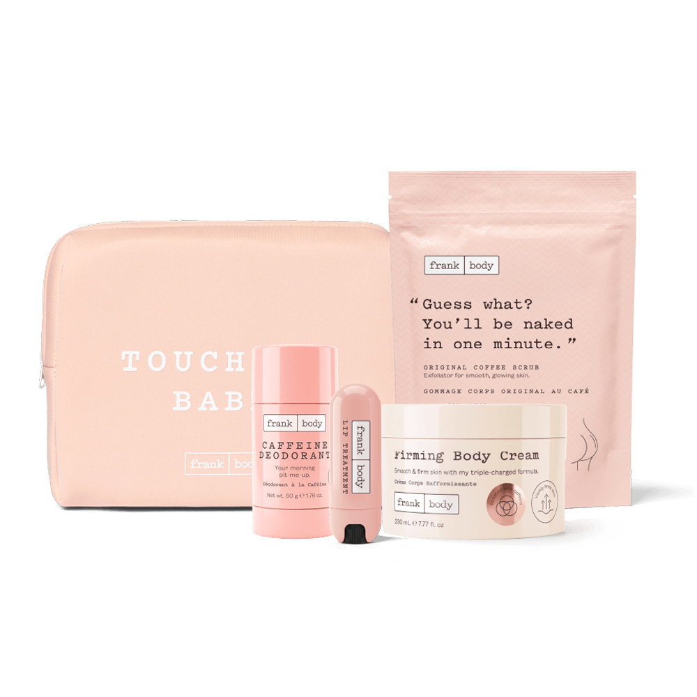 A pink skincare gift set from Frank Body on a white background, including a zippered pouch, a deodorant stick, a lip balm tube, a cream jar, and a body cream package.